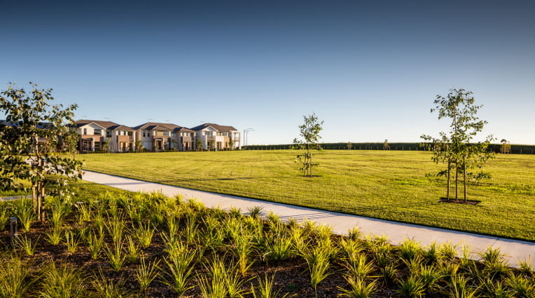 The Avenue by Mirvac parks with houses in the distance at Schofields